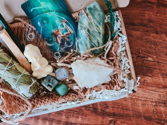 a wicker box filled with different crystals and gemstones on top of a wooden floor